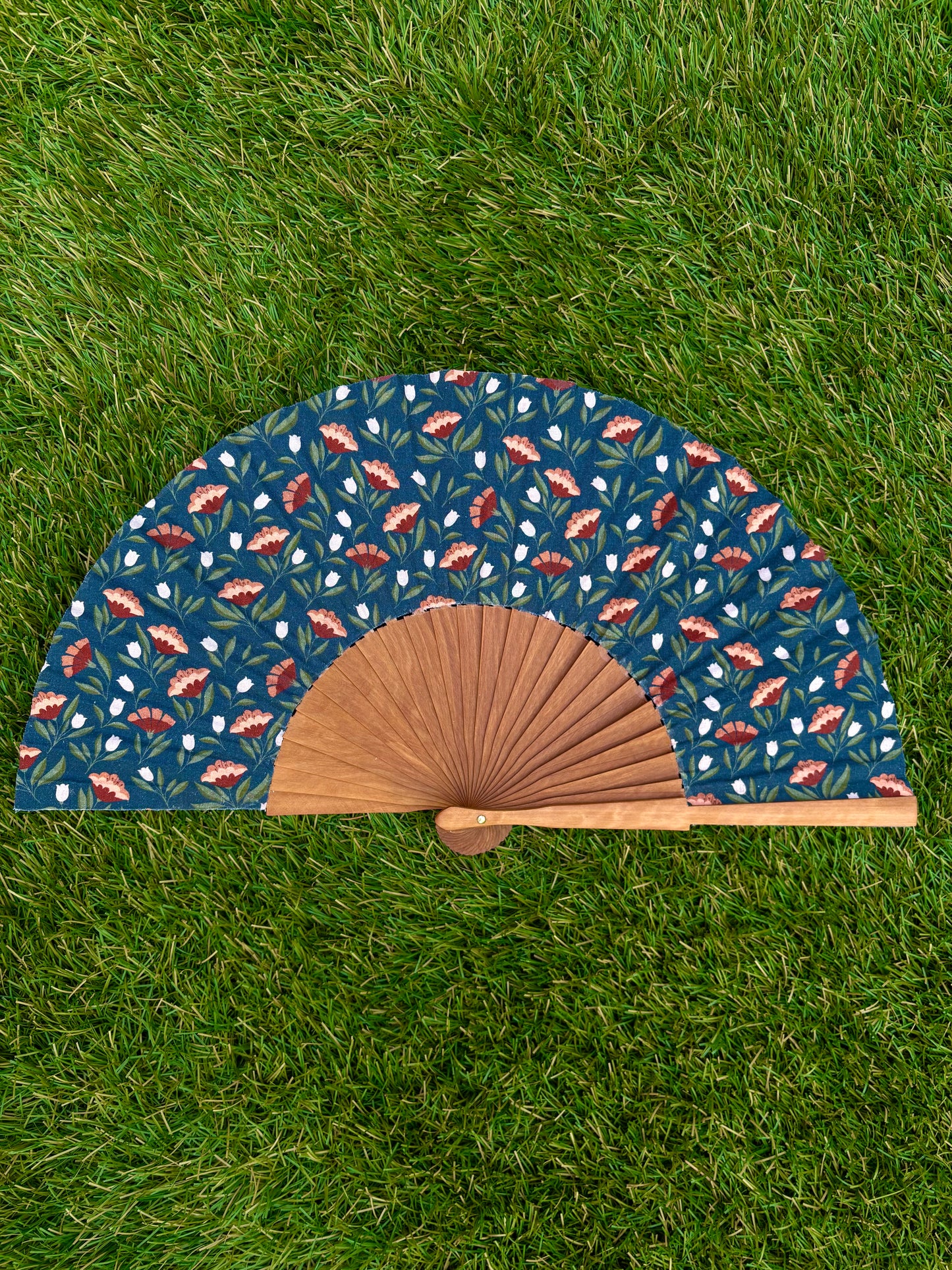 Abanico flores rojas y blancas sobre fondo azul oscuro